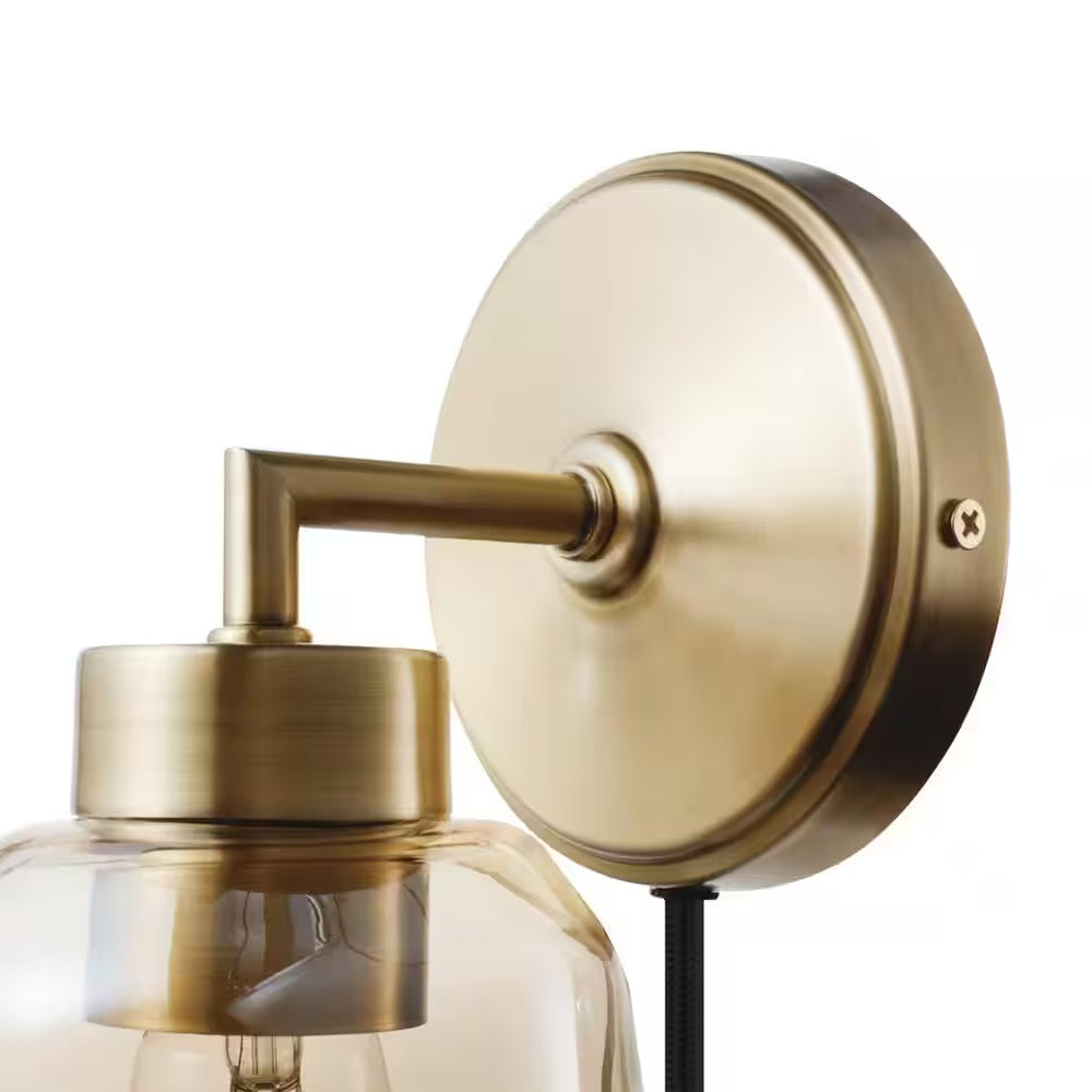 Globe Electric Salma 1-Light Matte Brass Plug-In or Hardwire Wall Sconce with Smoked Amber Glass Shade and In-Line On/Off Switch